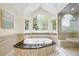 Spa-like bathroom with a luxurious soaking tub, a walk-in shower, and large windows with serene views at 6274 S Iola Ct, Englewood, CO 80111