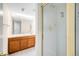 Bathroom featuring a glass-enclosed shower with bright tile and wooden vanity with a large mirror at 6274 S Iola Ct, Englewood, CO 80111