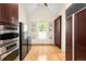 Bright dining area with large windows, custom shelving, and hardwood floors at 6274 S Iola Ct, Englewood, CO 80111