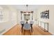 Bright dining room with hardwood floors, modern lighting, and large windows showcasing the backyard at 6274 S Iola Ct, Englewood, CO 80111