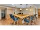 Basement bar area with a built-in sink, wood counters, and seating with pendant lights at 3535 Eagle Ridge Rd, Longmont, CO 80503