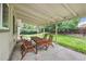 Covered back patio with wooden table and chairs overlooking the large yard at 3756 S Mission Pkwy, Aurora, CO 80013