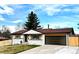 Charming single-story home with a well-manicured lawn, mature trees, and a two-car garage at 1853 S Urban Way, Lakewood, CO 80228
