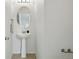 Simple powder room features a pedestal sink, chrome fixtures, and neutral tile flooring at 5574 W 72Nd Dr, Arvada, CO 80003