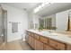 Bathroom with double sinks, a large mirror, and a tiled shower at 5574 W 72Nd Dr, Arvada, CO 80003