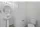 Clean half bathroom features a pedestal sink, toilet, and neutral decor at 5574 W 72Nd Dr, Arvada, CO 80003