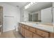 Bathroom with dual sinks, a shower, and a large mirror at 5574 W 72Nd Dr, Arvada, CO 80003