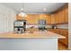 Kitchen features wood cabinets, stainless steel appliances, and a functional island with a sink at 5574 W 72Nd Dr, Arvada, CO 80003