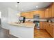 Kitchen features wood cabinets, a stainless steel appliances, and a functional island with a sink at 5574 W 72Nd Dr, Arvada, CO 80003