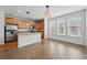Open kitchen features stainless steel appliances, a breakfast bar, ample windows, and hardwood floors at 5574 W 72Nd Dr, Arvada, CO 80003
