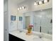 Modern bathroom featuring double sink vanity, large mirror, stylish lighting, and a glass-enclosed shower at 9283 Twenty Mile Rd # 308, Parker, CO 80134