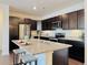 Modern kitchen boasts granite counters, dark wood cabinets, stainless appliances, and a functional kitchen island with barstool seating at 9283 Twenty Mile Rd # 308, Parker, CO 80134