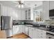 Well-lit kitchen features white cabinets, stainless steel appliances, granite counters, and hardwood floors at 1905 Niagara St, Denver, CO 80220