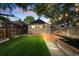 Backyard with lush lawn, mature trees, string lights, and a cute garage at 1031 S Pennsylvania St, Denver, CO 80209