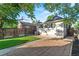 Backyard with lush lawn, brick and cement patio, and mature trees at 1031 S Pennsylvania St, Denver, CO 80209