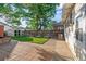 Landscaped backyard with green lawn, mature trees, shed and brick patio at 1031 S Pennsylvania St, Denver, CO 80209