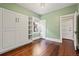 Light-filled bedroom features pale green walls, wood floors, and a built-in wardrobe at 1031 S Pennsylvania St, Denver, CO 80209