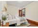 Bright bedroom features a large bed, neutral decor, wood trim and floors, and a sunny window at 1031 S Pennsylvania St, Denver, CO 80209