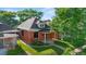 Attractive brick home with a landscaped lawn, inviting front porch, and lovely mature trees at 1031 S Pennsylvania St, Denver, CO 80209