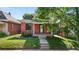Charming brick home featuring a well-manicured lawn, front porch, and mature tree in yard at 1031 S Pennsylvania St, Denver, CO 80209
