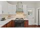This remodeled kitchen features an oven, range hood, granite countertops, and pendant lighting at 1031 S Pennsylvania St, Denver, CO 80209