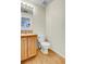 Simple bathroom with light wood cabinets, a toilet, and wood-look flooring at 14944 E Archer Cir, Aurora, CO 80012