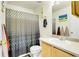 Functional bathroom with a patterned shower curtain, light wood vanity, and a clean, well-lit space at 14944 E Archer Cir, Aurora, CO 80012