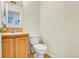 Simple bathroom with light wood cabinets, a toilet, and wood-look flooring at 14944 E Archer Cir, Aurora, CO 80012