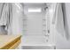 All white bathtub and shower combo with built in shelving and tiled walls at 14944 E Archer Cir, Aurora, CO 80012