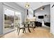 Cozy dining area with a fireplace, large windows, and wood-look laminate floors at 14944 E Archer Cir, Aurora, CO 80012