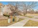 Charming two-story home featuring a well-manicured lawn, a two-car garage, and mature trees at 14944 E Archer Cir, Aurora, CO 80012