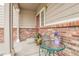 Charming front porch with brick accents, an ornate door, and lovely outdoor seating at 14944 E Archer Cir, Aurora, CO 80012