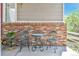 Front porch with charming seating, red brick accent wall, and a potted plant for a warm welcome at 14944 E Archer Cir, Aurora, CO 80012