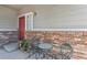 Charming porch features seating adjacent to a red brick wall, complemented by a potted plant at 14944 E Archer Cir, Aurora, CO 80012