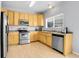 Well-lit kitchen featuring stainless steel appliances, laminate countertops, and wood-look flooring at 14944 E Archer Cir, Aurora, CO 80012