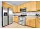 Well-equipped kitchen featuring stainless steel appliances and light wood cabinets at 14944 E Archer Cir, Aurora, CO 80012