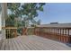 Back deck made of wood with a railing and a view of trees and a sunny, blue sky at 9784 W Euclid Dr, Littleton, CO 80123