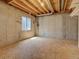 Unfinished basement with exposed ceiling, concrete walls, and window offering potential for customization at 9784 W Euclid Dr, Littleton, CO 80123