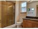 Bathroom featuring dark-stone countertops, wood vanity, and glass shower at 9784 W Euclid Dr, Littleton, CO 80123