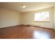 Spacious bedroom featuring laminate floors, light paint, and one large window at 9784 W Euclid Dr, Littleton, CO 80123