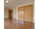 Bedroom featuring laminate floors and a large closet with sliding doors at 9784 W Euclid Dr, Littleton, CO 80123