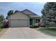 Inviting home exterior showcasing a well-maintained lawn, mature trees, and a charming blue front door at 9784 W Euclid Dr, Littleton, CO 80123