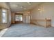 Spacious living room featuring plush carpet, natural lighting, and staircase with wood railing at 9784 W Euclid Dr, Littleton, CO 80123