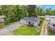 Aerial view of home with manicured front lawn, gravel driveway and mature trees in an established neighborhood at 8450 W 13Th St, Lakewood, CO 80215