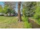 View of the home's back with a small stream and mature trees at 8450 W 13Th St, Lakewood, CO 80215