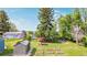 Spacious backyard features a garden shed, garden beds, and a charming red umbrella seating area at 8450 W 13Th St, Lakewood, CO 80215