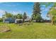 Wide backyard with shed, wooden planting beds, and mature trees at 8450 W 13Th St, Lakewood, CO 80215