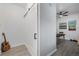 Bright entryway with a white barn door, guitar, and view into a bonus room with modern gray vinyl flooring at 8450 W 13Th St, Lakewood, CO 80215