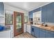 Bright kitchen featuring blue cabinetry, butcher block countertops, and stylish fixtures at 8450 W 13Th St, Lakewood, CO 80215