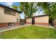 The backyard is grassed with a detached garage/shed; plenty of shade is provided by mature landscaping at 1243 Monroe St, Denver, CO 80206